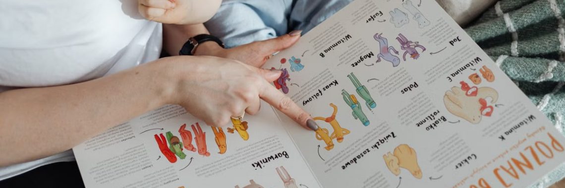 A comforting moment of a mother reading a colorful picture book with her child.